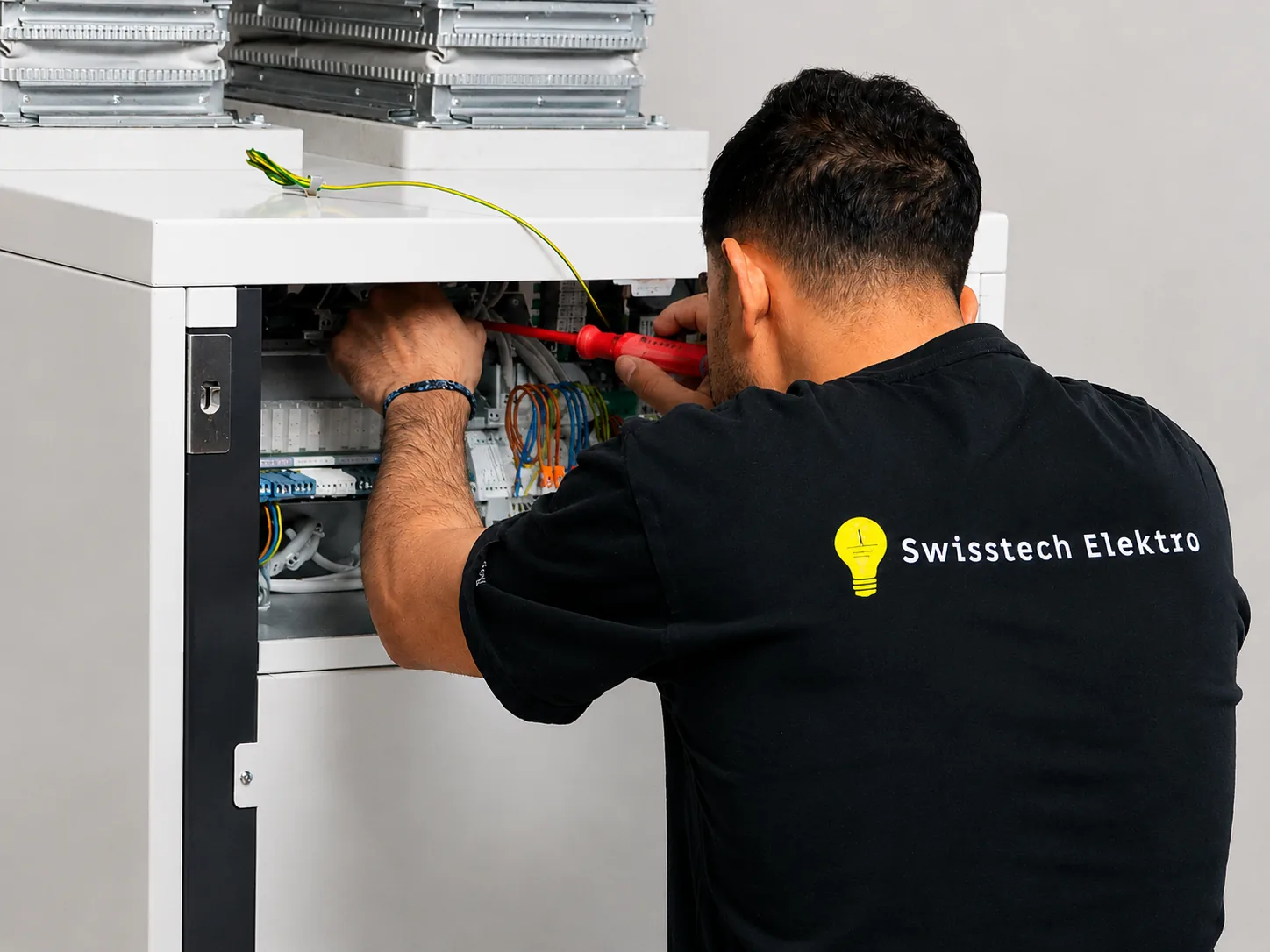 Elektromonteur von Swisstech Elektro bei der Verdrahtung einer Schaltanlage