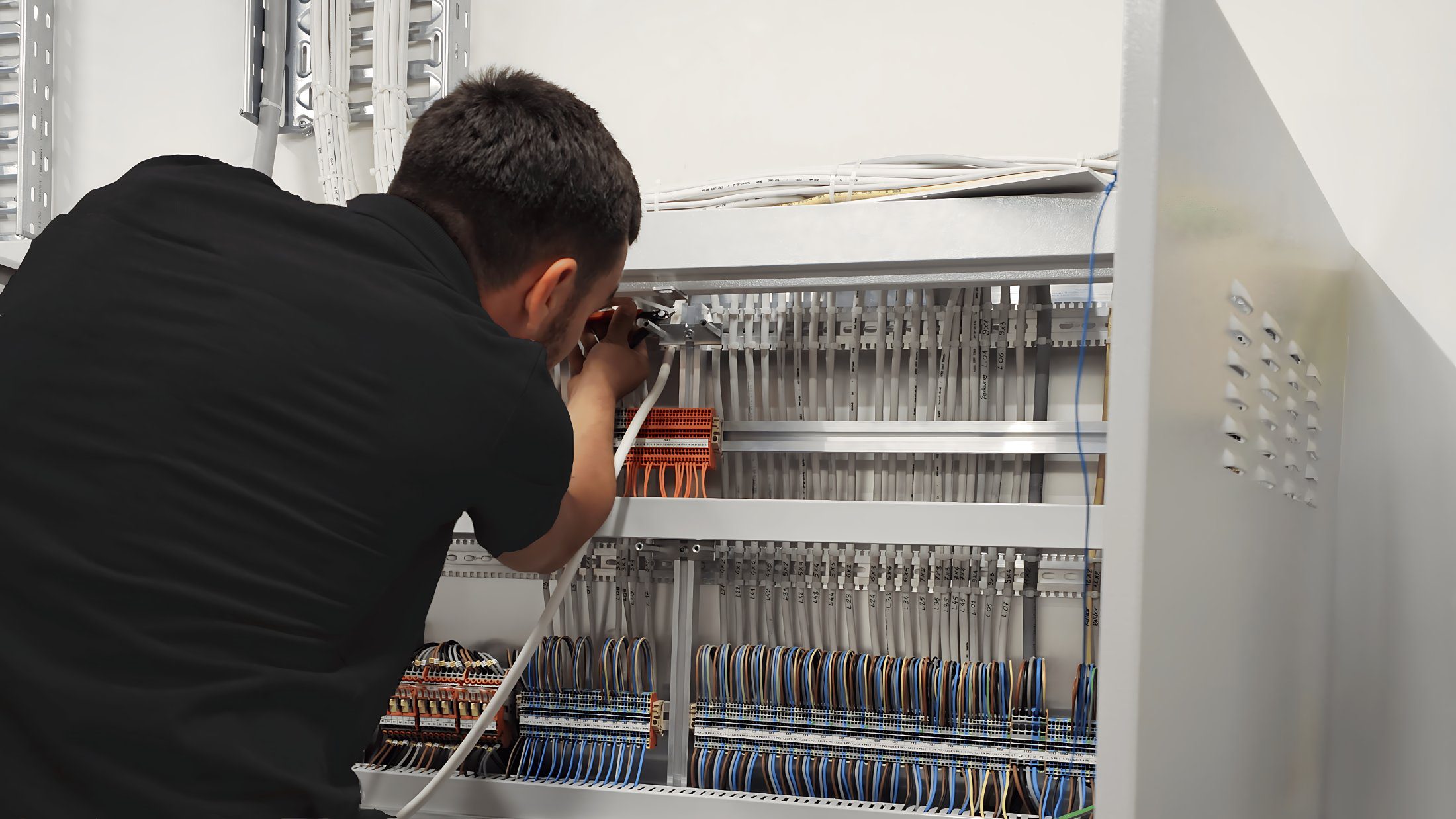 Elektromonteur von Swisstech Elektro bei der Verdrahtung einer Schaltanlage